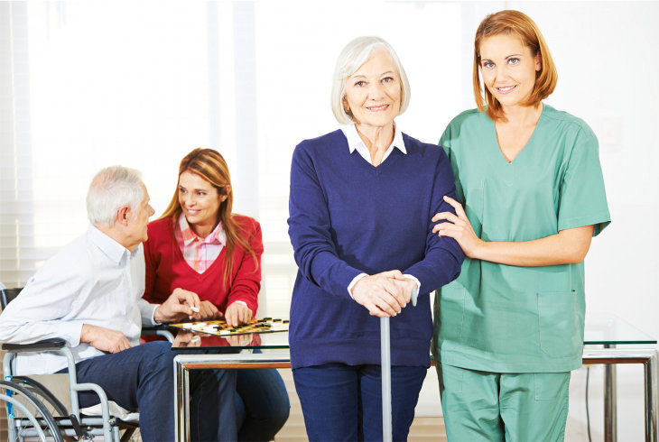 Caregiver with senior woman in nursing home