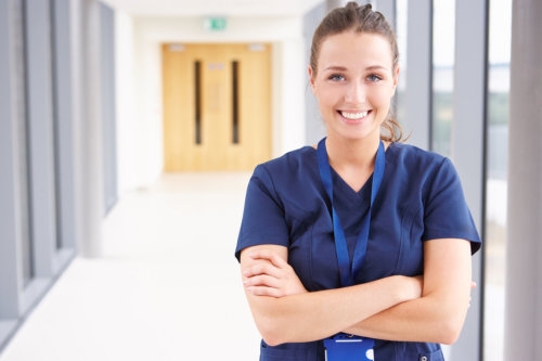 portrait of female nurse standing in hospital corridor